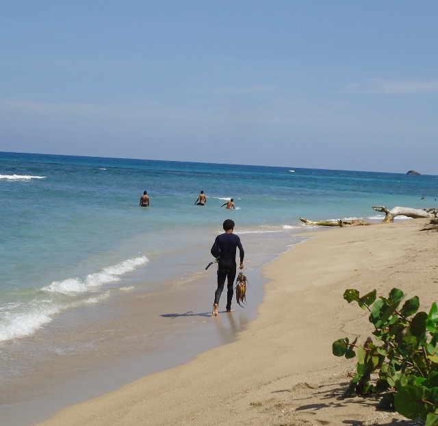 Young fisherman carrying his catch down Constabar beach near Puerto Plata.